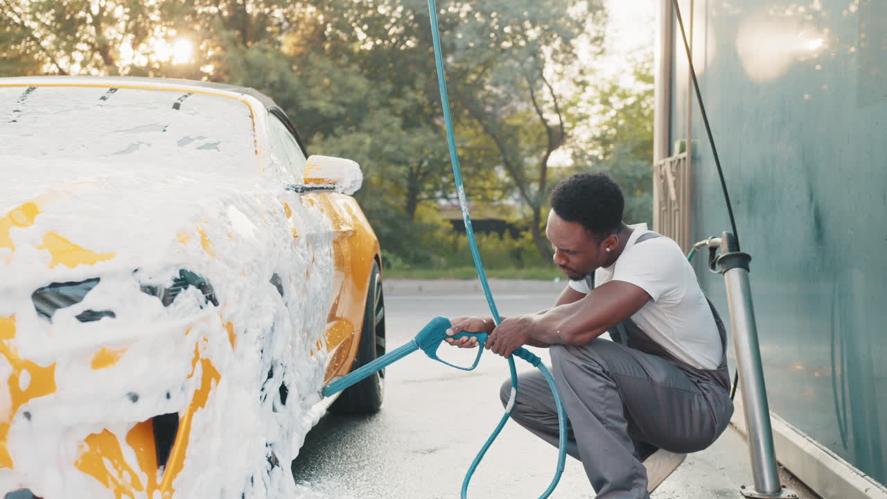 차 세탁장에서 노란색 컨버터블 차를 는 남자