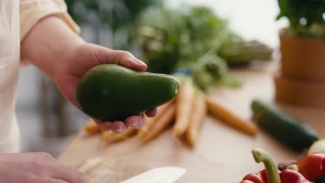 cerca de las manos de la mujer preparando aguacate en la cocina.