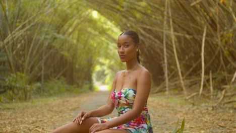 the beautiful bamboo cathedral of trinidad as a young woman sits and smiles under her branches