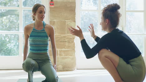 dos mujeres practicando yoga en el interior