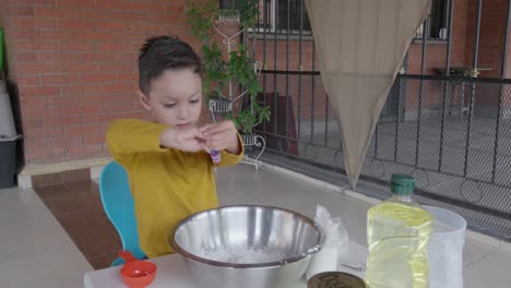 A-little-boy-pouring-color-and-juice-with-non-toxic-dough