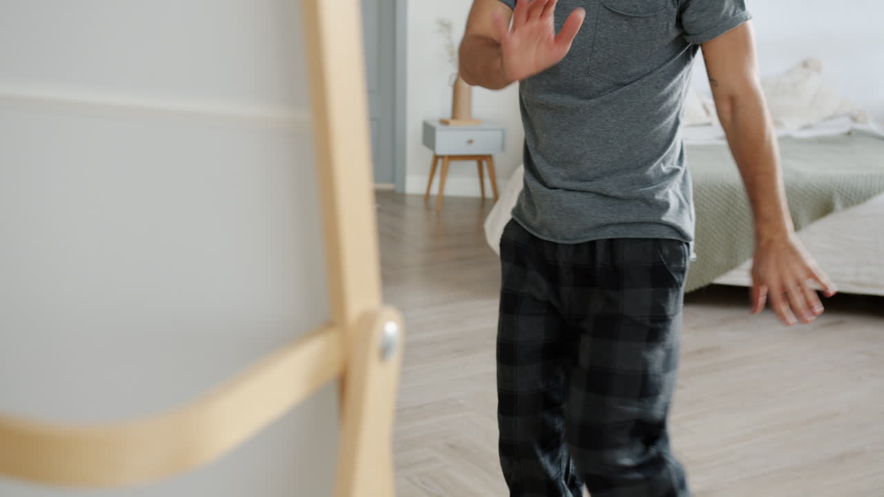 Man in pajamas dancing in front of a mirror