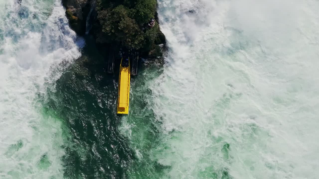 Exciting drone footage of a yellow boat near the powerful Rhine Falls