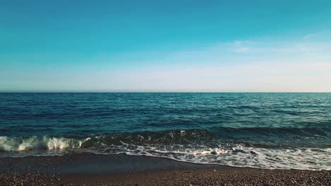 waves at the beach on a clear blue sky