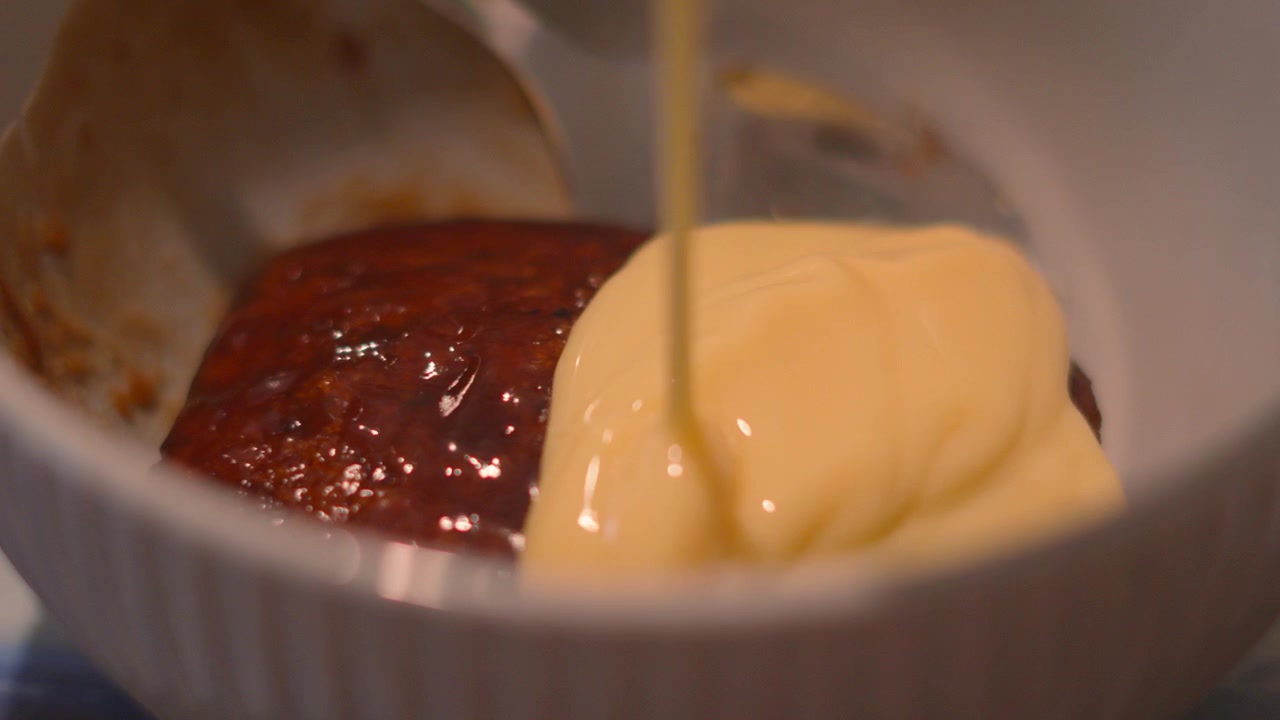 Fristende Sticky Toffee Pudding med vaniljesaus sakte helles over som en søt dessert. 4K.