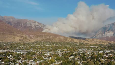toma aérea de dc-10 arrojando retardante de fuego en un incendio forestal en una montaña sobre la ciudad desde una distancia segura, orem utah