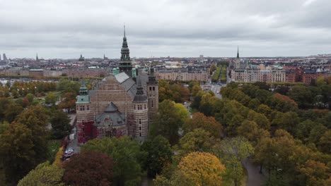 top-down-aerial-view-of-the-nordic-museum-in-stockholm,-sweden,-you-can-see-the-island-Djurgarden,-in-the-background-the-city-with-its-canals-and-boats