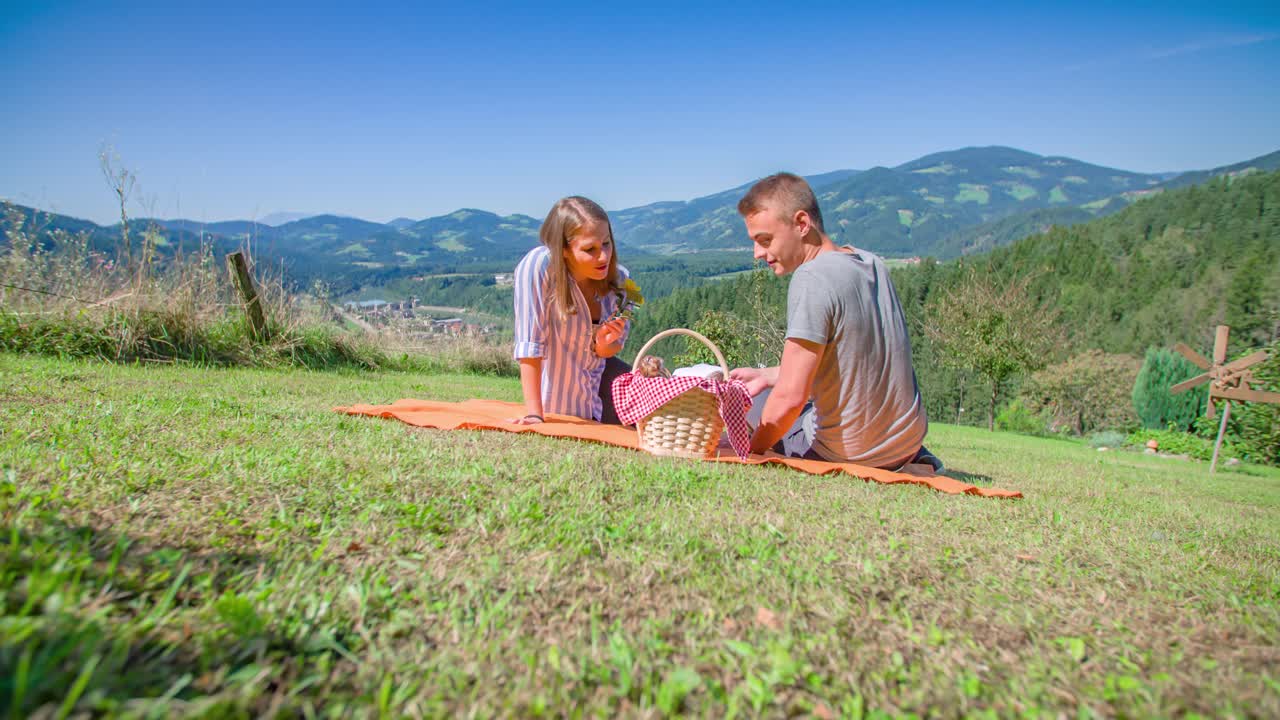 매력적인 젊은 커플이 로맨틱한 피크닉을 즐기는 낮은 앵글 샷