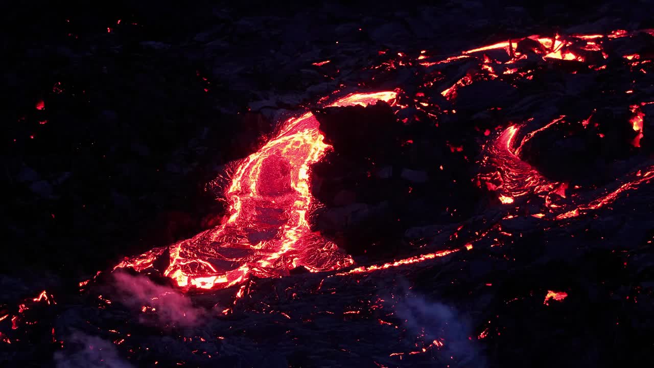 río de lava caliente que fluye desde el cráter del volcán fagradalsfjall durante la erupción por la noche