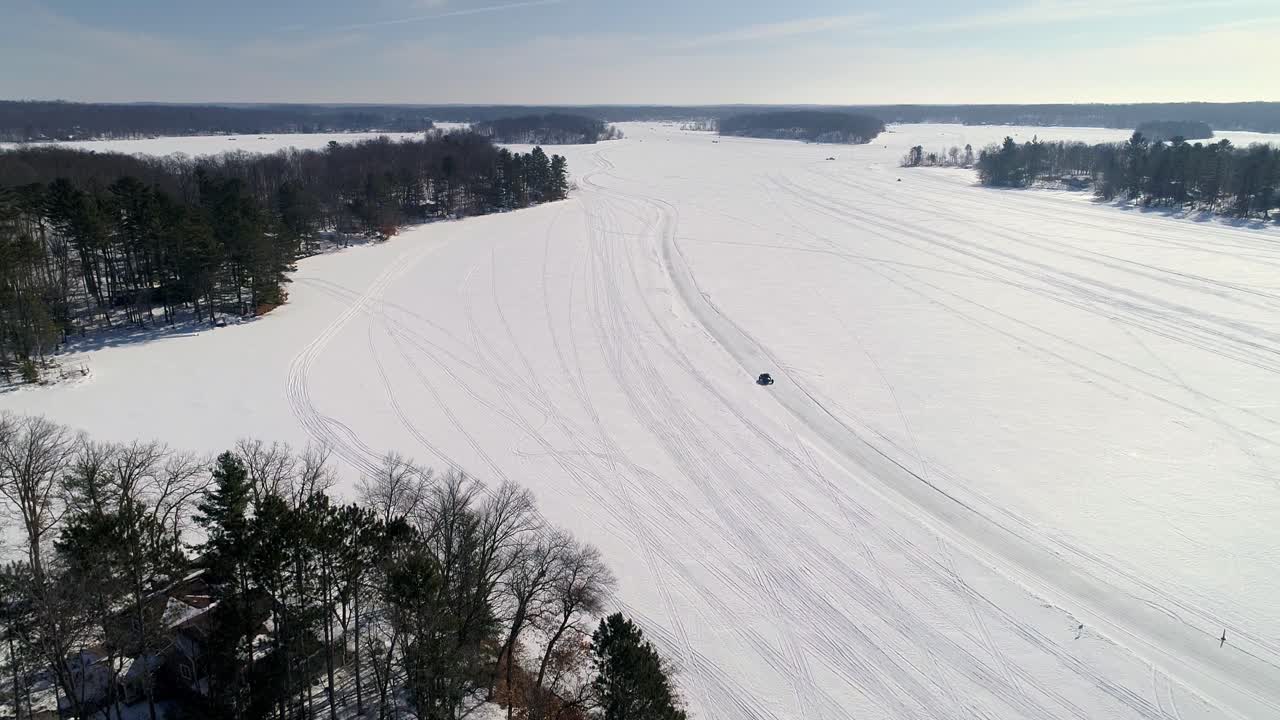 Aerial View of a Frozen Lake with Snowmobile Tracks in Winter
