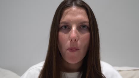 close up shot of a women looking at the camera eating a chocolate