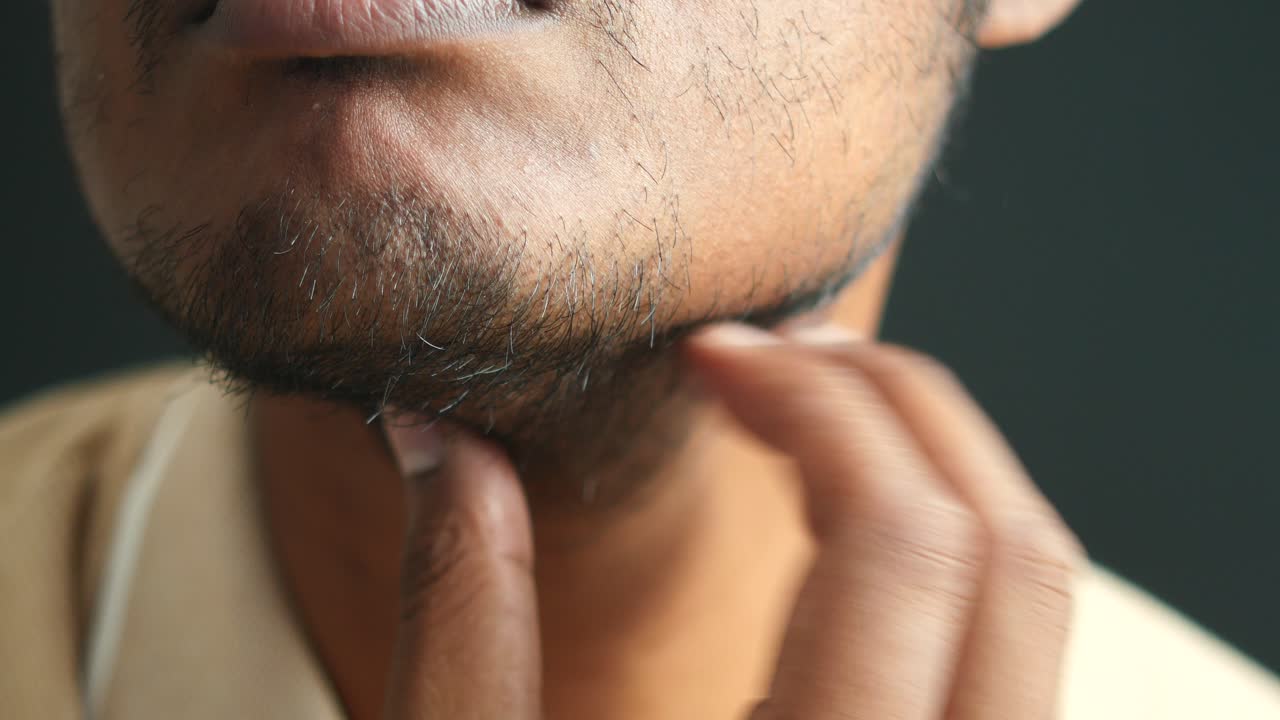 hombre tocando su barbilla