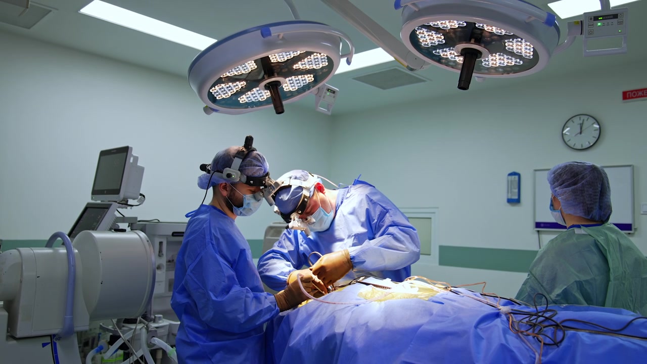 Kiev, Ucraina, 5 maggio 2026: Chirurghi con lampade frontali eseguono un intervento chirurgico alla colonna vertebrale in sala operatoria