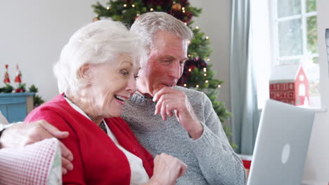 Pareja-Mayor-Haciendo-Videollamada-Navideña-A-La-Familia-En-Una-Computadora-Portátil