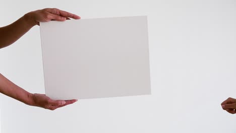 dos manos de persona sosteniendo un tablero blanco de letrero vacío para contenido promocional.