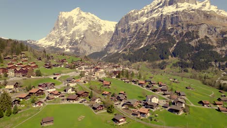 Imágenes-Aéreas-De-Drones-Que-Se-Elevan-Y-Empujan-Sobre-Un-Pintoresco-Pueblo-De-Montaña-Frente-Al-Monte-Wetterhorn-En-Los-Alpes-Suizos