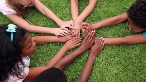 Pupils holding hands together outside 