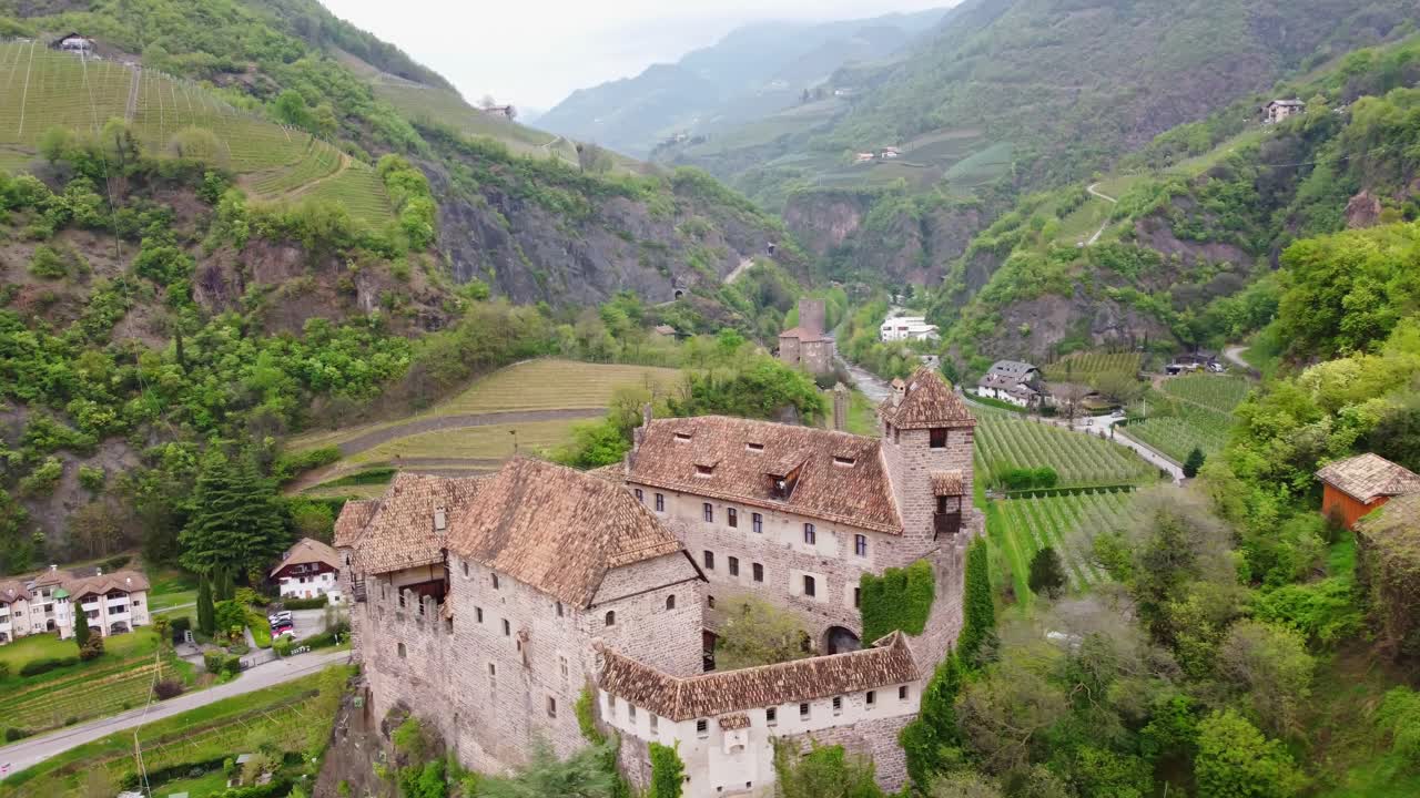 Bird's-eye view of Roncolo Castle surrounded by lush green nature, offering a scenic perspective