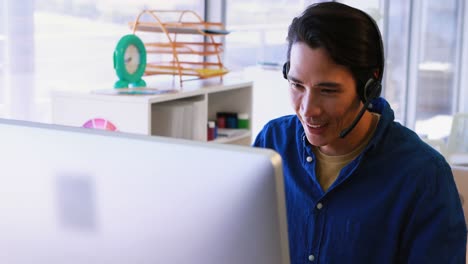 Ejecutivo-Masculino-Con-Auriculares-Trabajando-En-La-Computadora-En-Su-Escritorio-4k