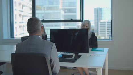 business colleagues sitting at meeting table together