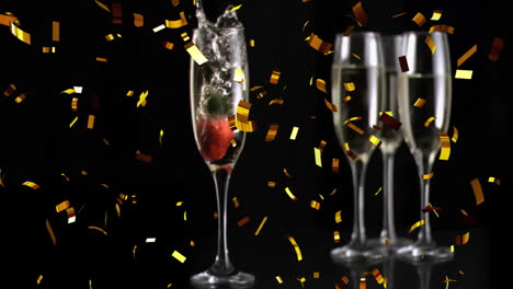 animation of confetti over glasses of champagne with strawberries on black background