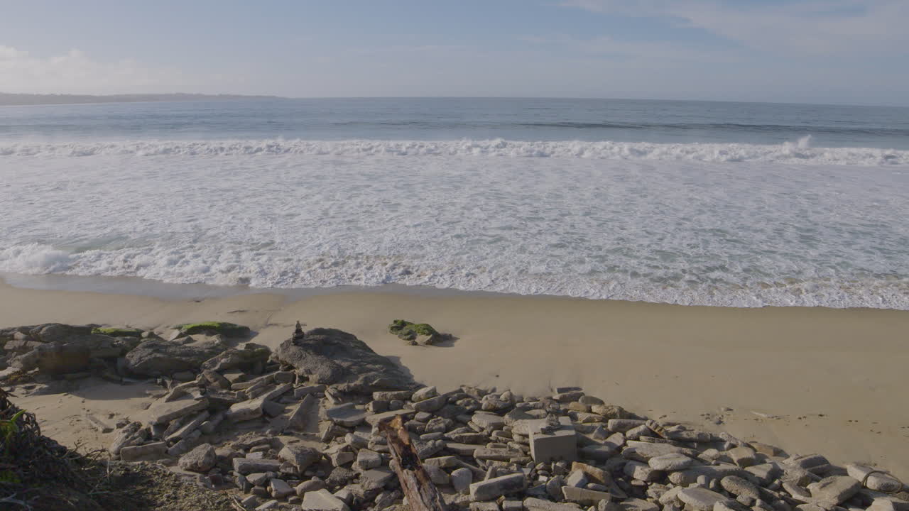 toma en cámara lenta de olas rompiendo en una costa rocosa del sur de california
