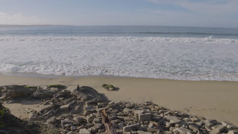 slow motion shot of waves crashing onto a rocky shoreline of southern california