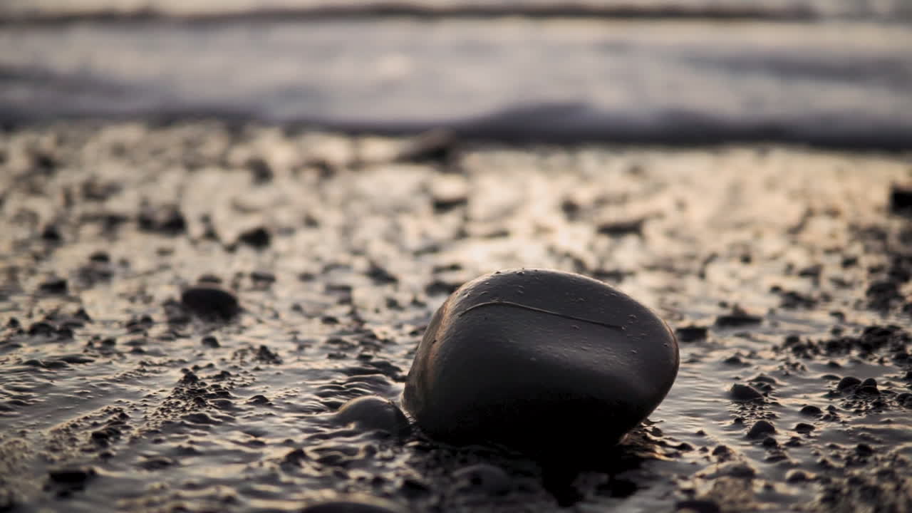 자갈과 바위 slowmo를 통해 해변 파도와 물 스트리밍을 닫습니다.