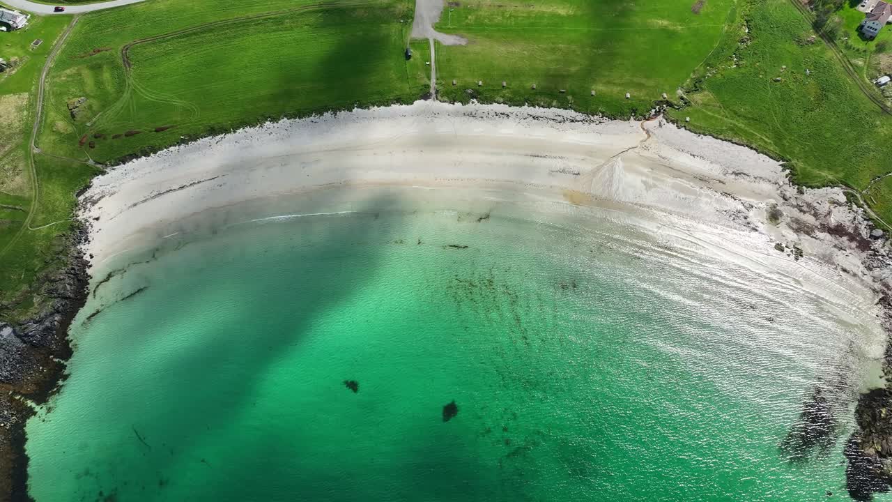 Hov beach in Gimsøy Lofoten with turquoise water, waves, grass and scenic summer coastline