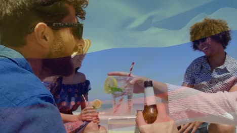 animación de ondear la bandera de colombia sobre un grupo de amigos divirtiéndose en la playa