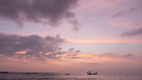 nubes grises en rosa pastel color dulce del cielo en la puesta o amanecer tiempo. paisaje romántico del mar y silueta pequeño barco de pesca flotando en la costa. vista panorámica fondo del paisaje del cielo.