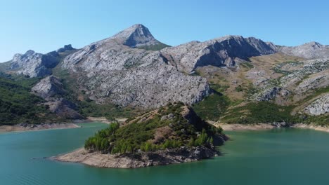 Luftaufnahme-Mit-Drohne-In-Rotation-Des-Sees-Riaño-Und-Des-Bergkettenhintergrundes