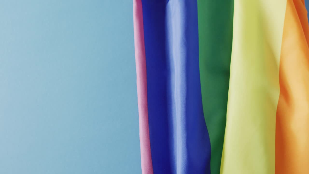 복사 공간과 함께 파란색 배경 위에 무지개 직물의 비디오