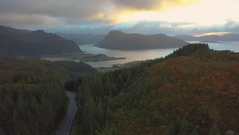 Drone-shot-approaching-a-coastal-town-in-Norway-with-cloudy-weather-in-sunset