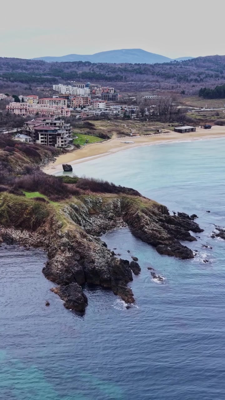 Vista sulla costa con sponde rocciose e acque calme vicino a una zona balneare