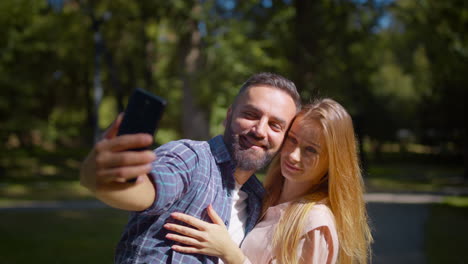 una pareja tomando una selfie en el parque.