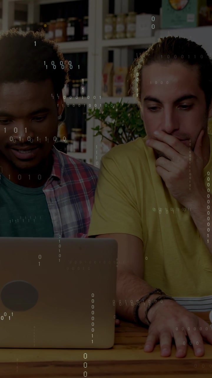 Vertical video: Binary overlay appearing two men leaning over laptop pointing typing checking data