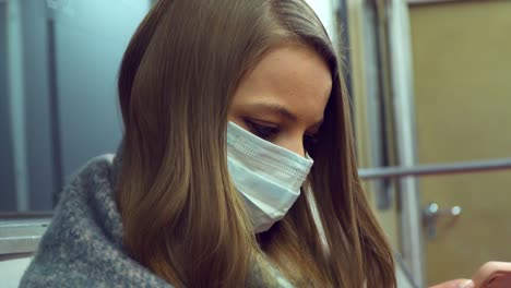 chica con una máscara médica sentada en un vagón del metro y la pantalla de desplazamiento