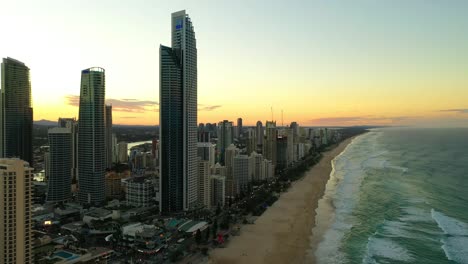 Tiro-Panorámico,-Paraíso-De-Los-Surfistas-Al-Atardecer,-Cielos-Dorados,-Torres-De-Apartamentos-De-Gran-Altura