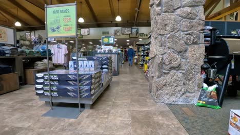 pov - walking between clothing and outdoor cooking departments in cabela's;concepts of outdoor life and adventure