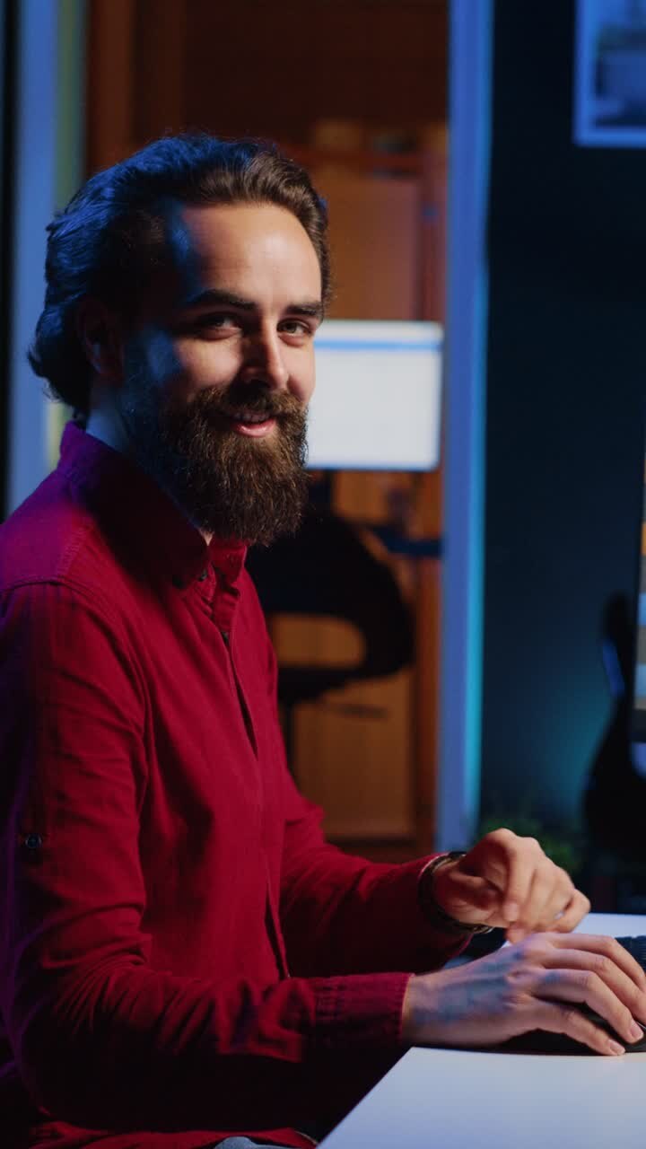 Vertikales Video: Ein KI-Fotoeditor macht eine Pause, nachdem er die Farbkorrektur von Bildern vorgenommen hat, und entspannt sich mit seinem Smartphone