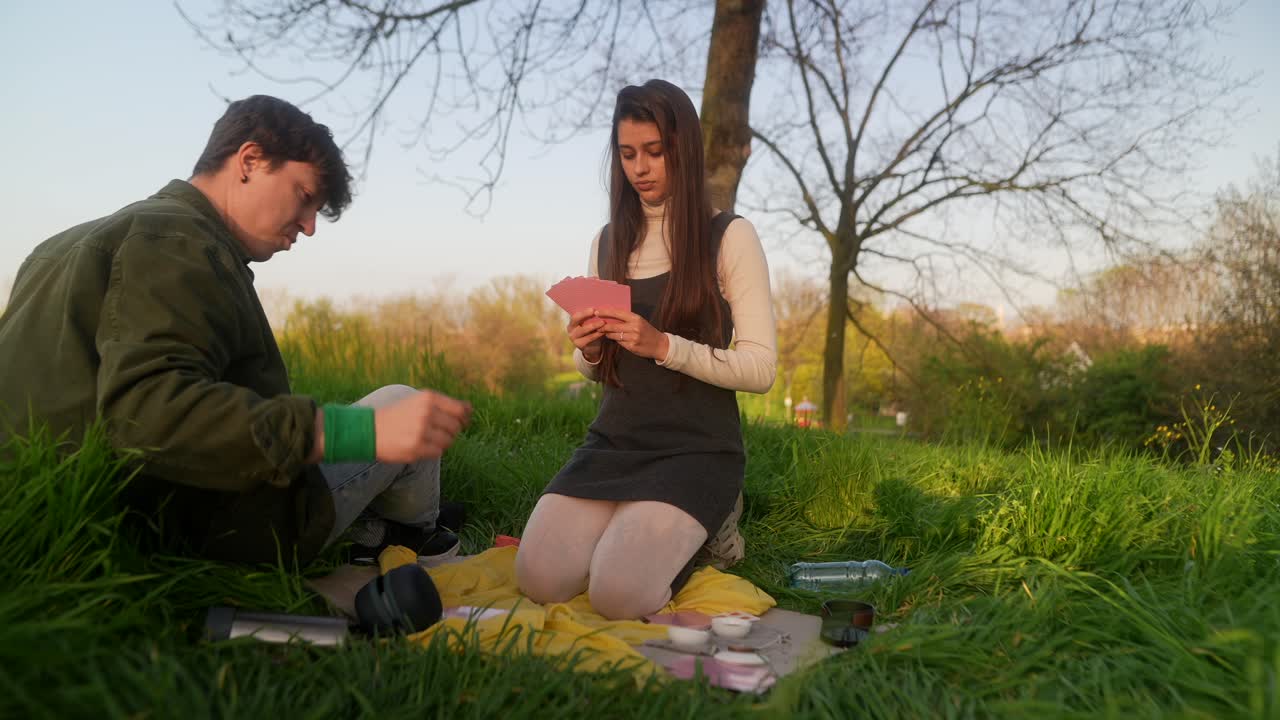 Young Adults Playing Cards in a Park