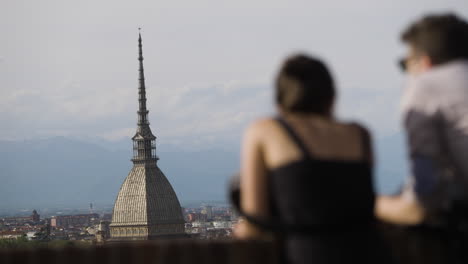 out of focus tourists looking over turin skyline and mole antonelliana