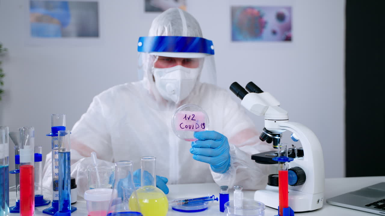 Scientist Examining Petri Dish with COVID-19 Sample