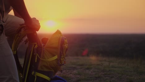 collect things on the journey. the man puts things in a hike, puts them in a backpack. at sunset