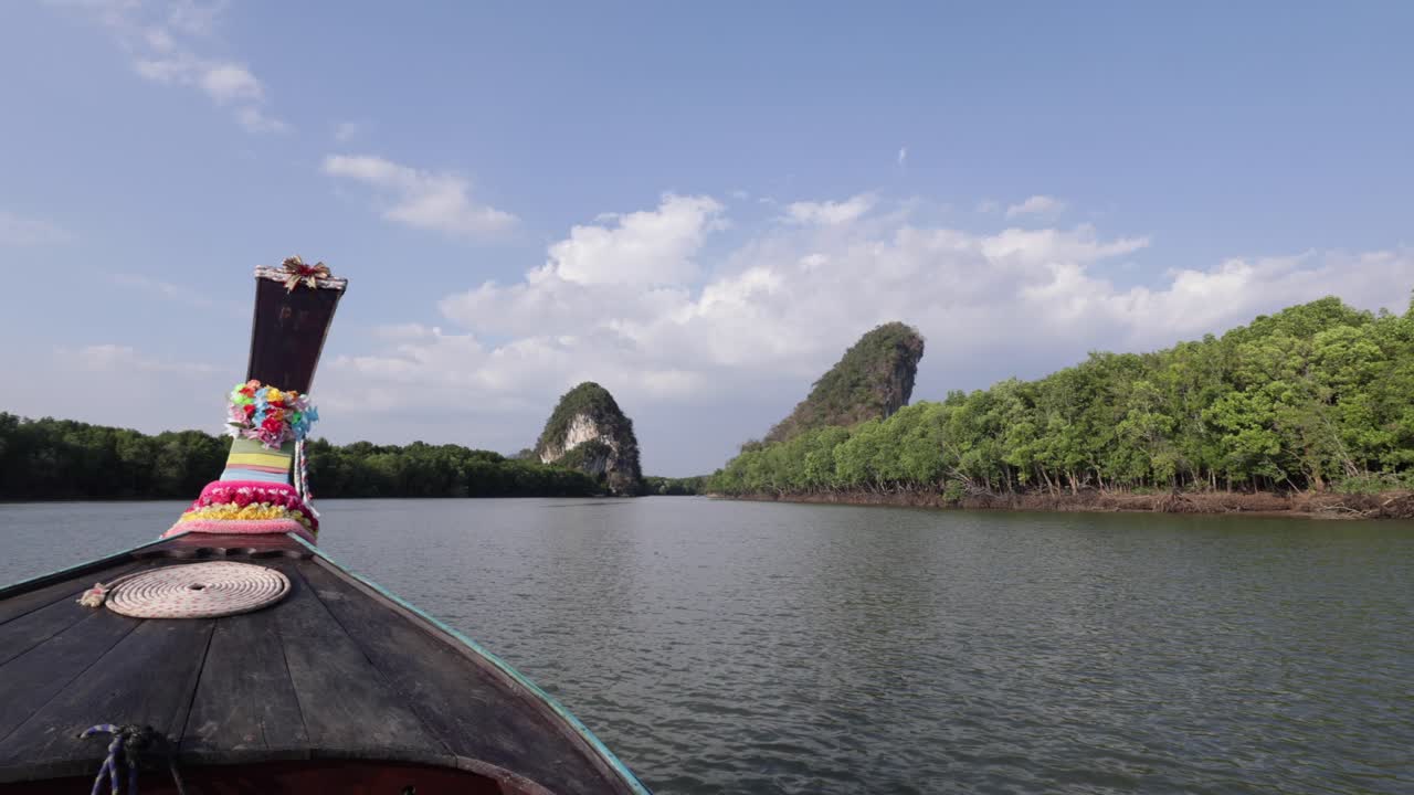 태국 크라비 타운 양쪽에 있는 하얀 모래 해변과 맹그로브 숲 일몰 동안 강을 따라 달리는 화려한 꽃으로 장식된 나무 태국 롱테일 보트의 오른쪽 카메라 패닝