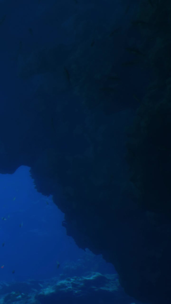Vista subaquática mostrando rochas e água em um cenário de oceano profundo.