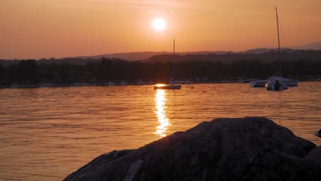 Boote-Schwingen-Vor-Anker-Im-Gardasee,-Italien-Bei-Sonnenuntergang,-St.-Franziskus-Auf-Der-Insel-Assisi