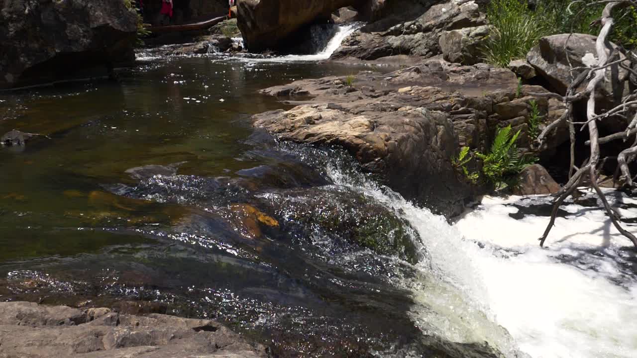 Río de aguas cristalinas fluyendo sobre rocas