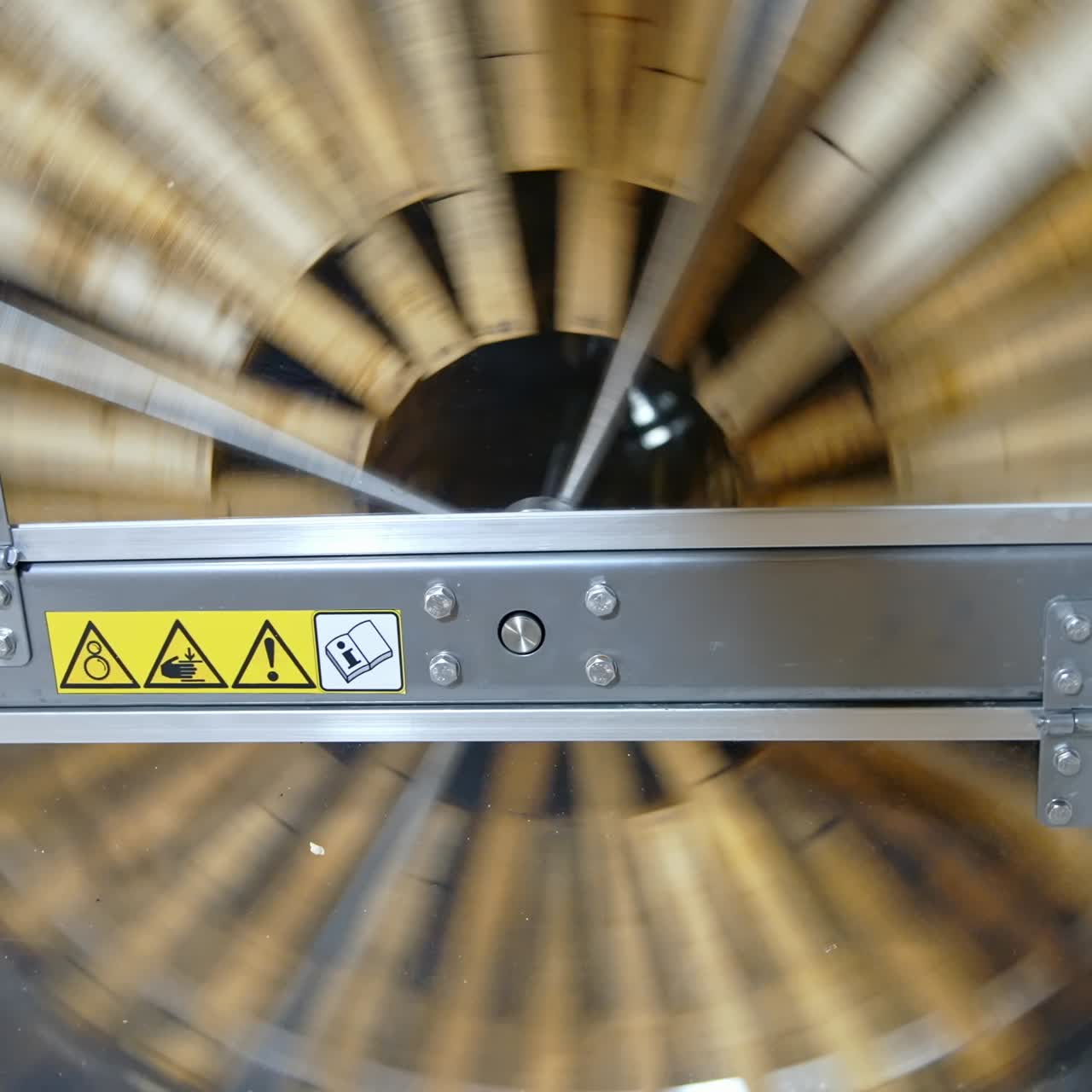 Spinning of honey extractor. Removal of honey from the honeycomb in special device. Centrifuge machine is pumping organic honey while spinning with frames with honeycombs. Top view